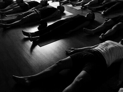 Hombres y mujeres en sus tapetes de yoga practican la respiración holotrópica