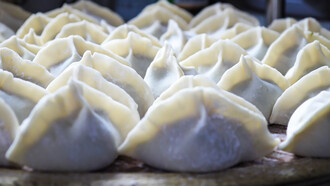 Uzbek food specialty: manti dumplings filled with spiced meat and served with a dollop of yogurt