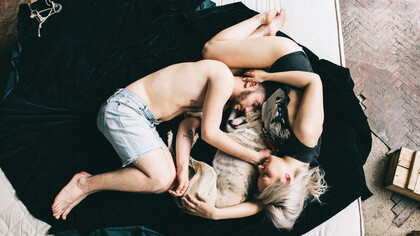 A couple curls up with their dog for some sleep