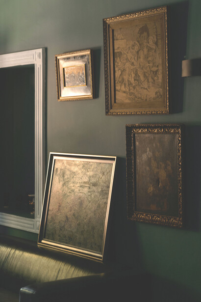 Pinturas colgadas y apoyadas sobre un sillón