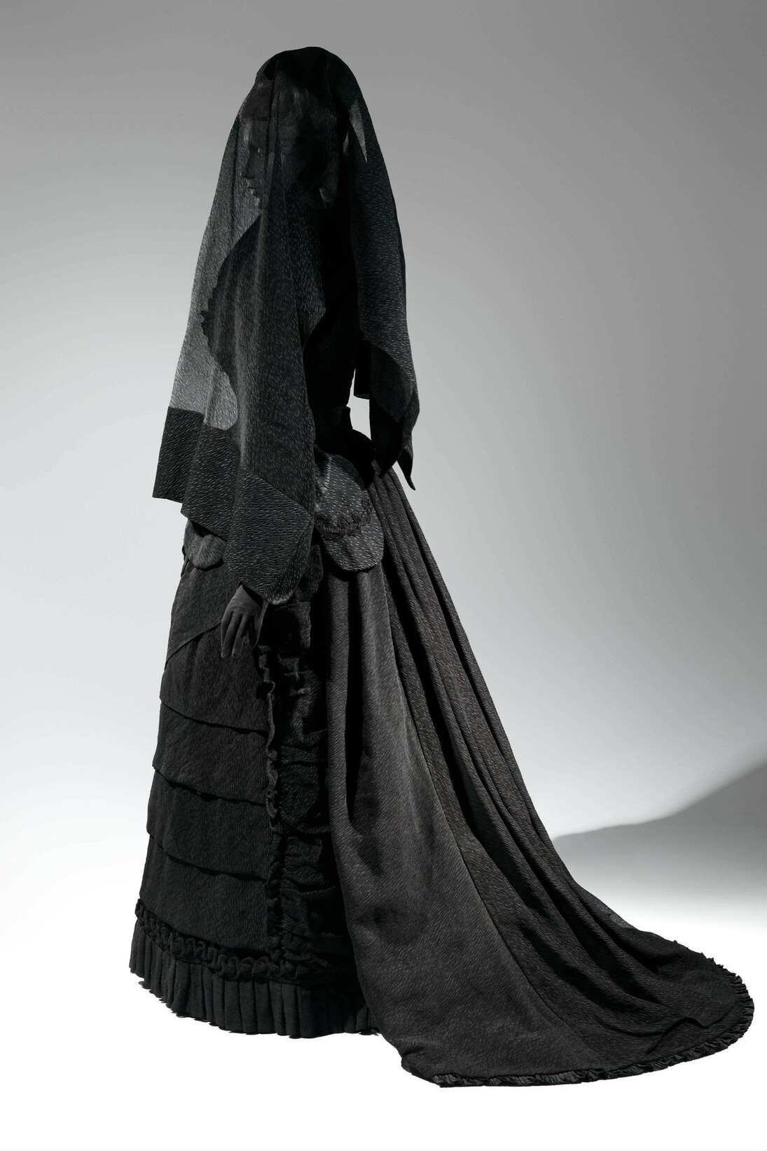 Mourning Ensemble, 1870-1872, Black silk crape, black mousseline. The Metropolitan Museum of Art, Brooklyn Museum Costume Collection at The Metropolitan Museum of Art, Gift of the Brooklyn Museum, 2009; Gift of Martha Woodward Weber, 1930 (2009.300.633a, b), Veil, ca. 1875, Black silk crape. The Metropolitan Museum of Art, Gift of Roi White, 1984 (1984.285.1). Photo: © The Metropolitan Museum of Art, by Karin L. Willis