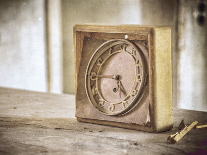 Un reloj antiguo encima de una vieja cómoda