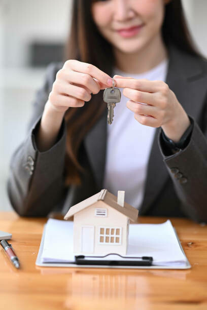 A handshake and key exchange between a real estate agent and happy buyers, sealing the deal on a new home