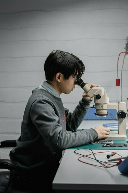A skilled worker restoring a dismantled electronic device with precision, symbolising sustainable solutions that keep valuable technology in use for longer