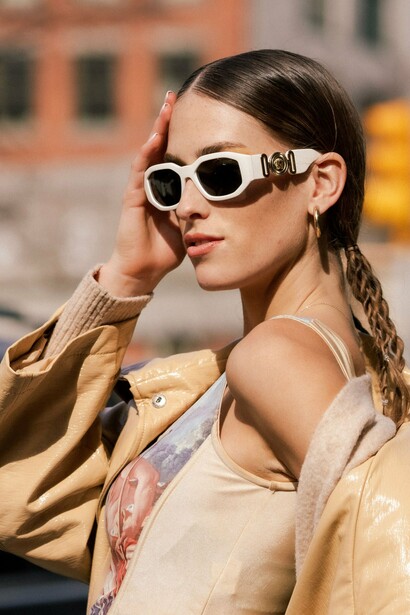 A poised model showing off signature Versace eyewear, symbolizing the brand’s commitment to statement-making fashion