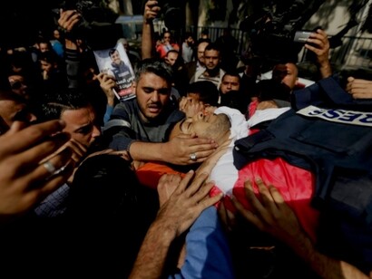 Hombres cargan con el cadáver de un palestino asesinado por las fuerzas de Israel