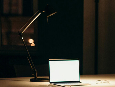 Luz acesa em escrivaninha com computador ligado