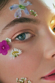 A cantora Lorde iluminada pelo sol e beijada por pétalas de flores tropicais