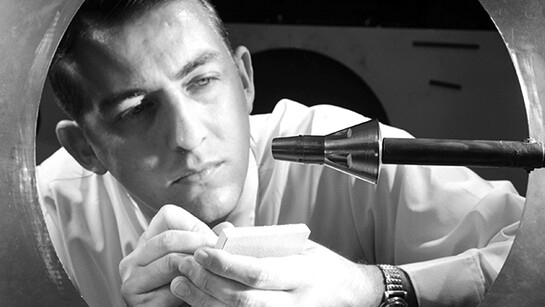 A researcher inspects a Gemini spacecraft mounted on a sting in the 11-Inch Hypersonic Tunnel in 1962. Courtesy NASA Langley Research Center