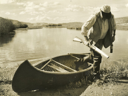 Ernest Hemingway stepping out of a canoe, Sun Valley, Idaho, October 1941. Photograph by Robert Capa, Ernest Hemingway Photograph Collection, John F. Kennedy Presidential Library