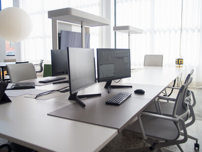 Ambiente corporativo contemporâneo onde softwares analíticos exibem informações estratégicas em tempo real. A digitalização dos processos é um passo importante para a implementação de sistemas avançados de gestão de custos