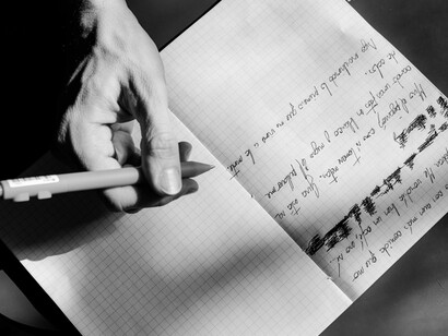 Una persona escribe en un cuaderno una serie de anotaciones, acompañadas de varios tachones