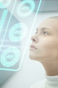 Close-up of a woman studying a glowing screen, reflecting the growing connection between humans and artificial intelligence