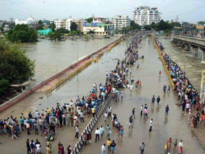 Residents look at flood water on a major highway in Chennai