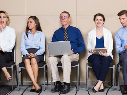 Five candidates seated in a waiting room, with one being an older individual