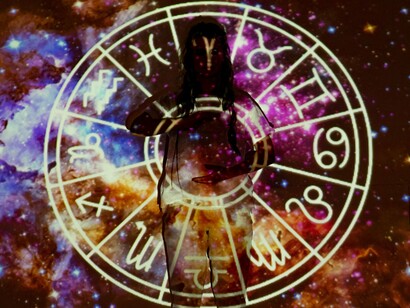 A woman standing in front of an expansive astrological display, symbolising the widespread appeal of cosmic explanations without scientific validation
