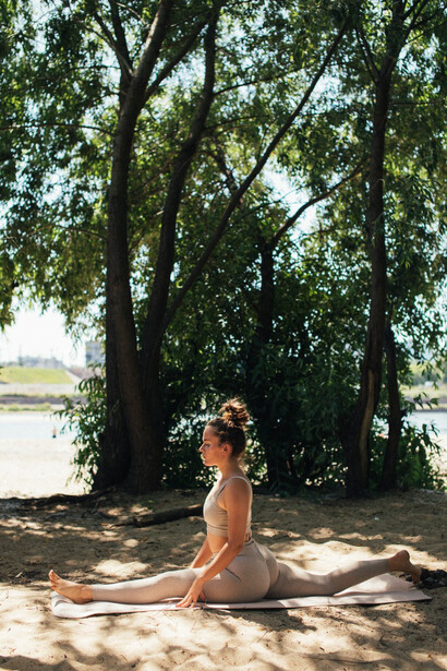 Ragazza fa yoga sulla sabbia in una pineta