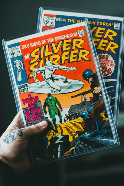 A fan enjoys reading a Silver Surfer comic book, reflecting Marvel's iconic graphic design and cultural influence