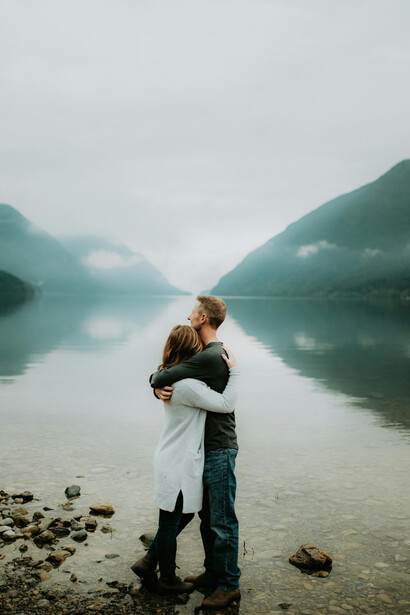 A couple resting by a river amid a mountain valley
