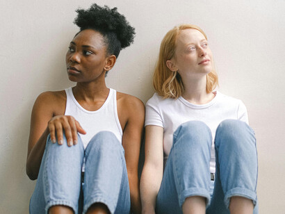 Two young girls sitting next to each other, looking around