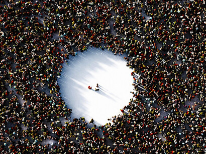 A lone figure breaks away from the masses, symbolizing courage, individuality, and the willingness to take risks