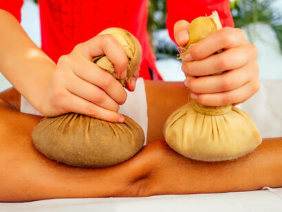 Ayurvedic Abhyanga massage therapy being performed on an Indian woman in a serene resort setting in Goa, India