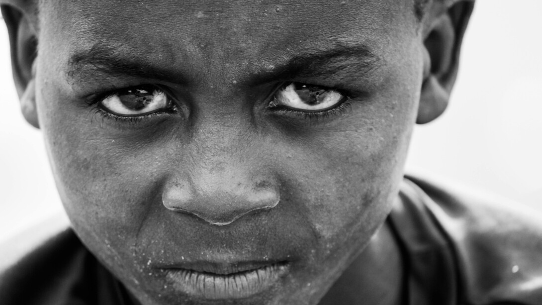 A black child stares defiantly into the camera