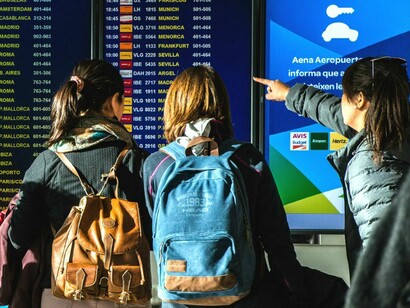 Young women checking the time of their flight in the airport