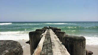 A weathered pier stretches into the Atlantic along North Carolina’s untamed coast, where history and natural beauty meet
