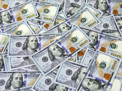 US dollar banknotes on a table. Investing is often hailed as a prime example of a non-zero-sum game