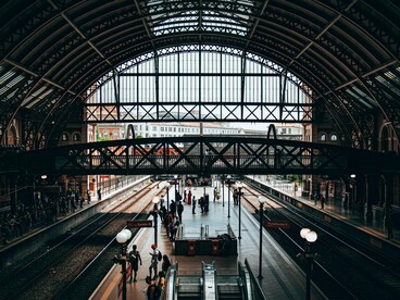 A bustling train station where countless journeys converge, representing the paths people take in search of safety, opportunity, and belonging