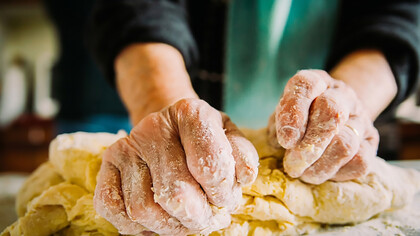 Close-up of an elderly Italian woman’s hands making fresh pasta by hand