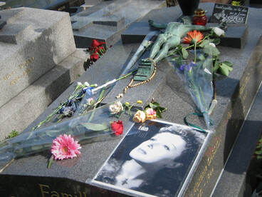 È un luogo in cui la morte non cancella, ma scolpisce la memoria nei gesti quotidiani dei visitatori. Nella foto la tomba di Edith Piaf. Cimitero di Père-Lachaise, Parigi, Francia