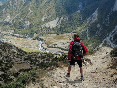 A man hiking from Manang for acclimatization before attempting the Thorung La Pass on the Annapurna Circuit, Nepal