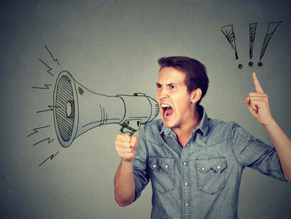 A frustrated young man yells into a megaphone, feeling isolated and overwhelmed by the constant stream of political news