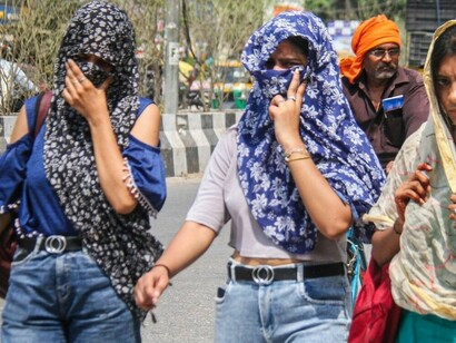 In India, people walk outdoors with their faces and heads covered, shielding themselves from the intense summer heat