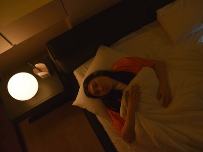 A woman lying on her bed, she can't sleep in the middle of the night, suffering from insomnia