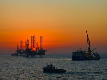 Offshore drilling platforms in calm waters, reflecting the immense economic power behind fossil fuel production