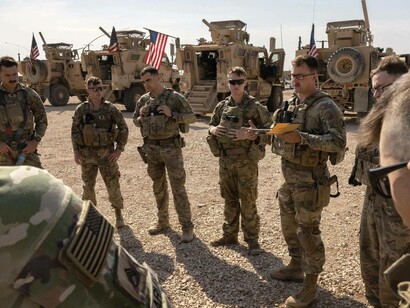 US military soldiers receiving instructions from their commanding officer