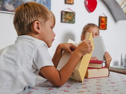 A boy and a girl reading at a table, practicing self-discipline through focused learning
