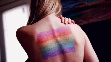 A transgender individual with the symbol of the LGBT community on their back