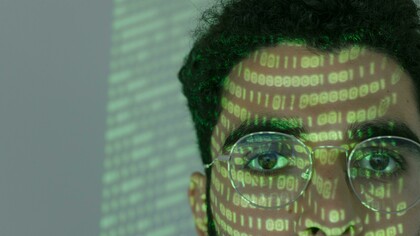 Codici riflessi sul viso di un uomo: "Cosa significa davvero “imparare” quando il nostro interlocutore non è un altro essere umano, ma una macchina come l’Intelligenza Artificiale Generativa (GenAI)?"