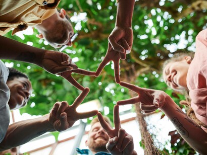 Team joins fingers to work together in the shape of a star