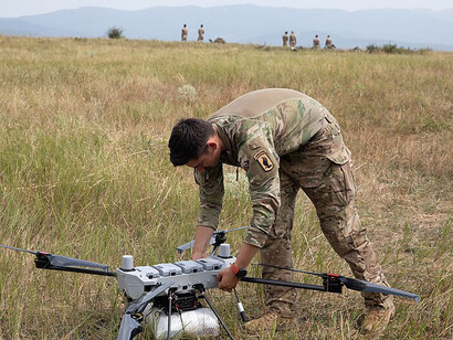 United States Army Spc. Tyler Dooros conducts preflight checks on a PDW C100 drone at the Norio Training Area in Georgia on Aug. 2, 2025, during the military exercise Agile Spirit 25. Assigned to Hawkeye Platoon, Headquarters and Headquarters Troop, 1st Squadron, 91st Cavalry Regiment, 173rd Airborne Brigade, Dooros prepares the drone for a live demonstration showcasing its aerial resupply and payload deployment capabilities using custom 3D-printed attachments
