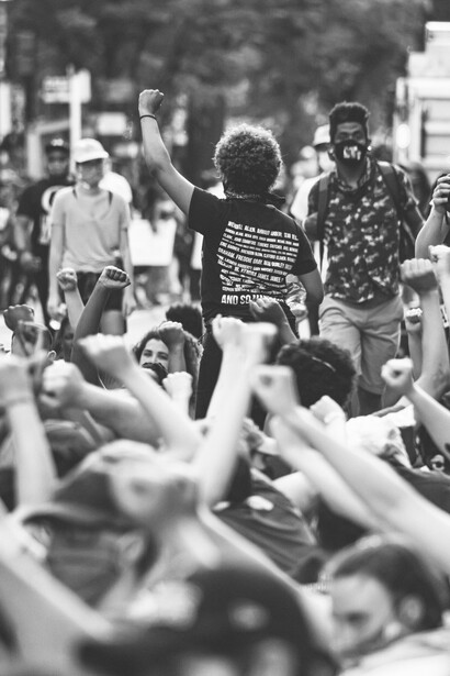 Un joven levanta su puño sobre los demás, rodeado de personas que reclaman contra la corrupción política