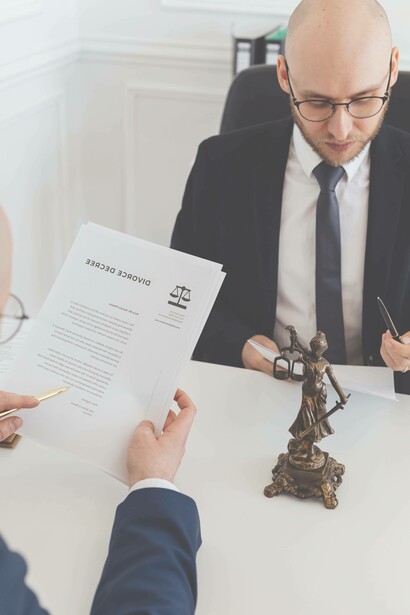 Man reviews divorce papers with lawyer