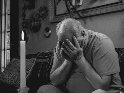 Com o rosto apoiado sobre as mãos e uma vela acesa à sua frente, um homem permanece em silêncio. Em muitos momentos, a reflexão silenciosa expressa sentimentos que as palavras não conseguem traduzir