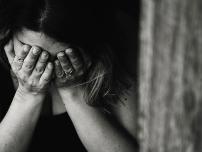 Woman sat with her head in her hands