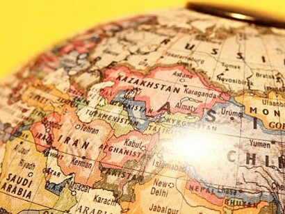 A weathered vintage globe with Pakistan, China, and India prominently marked on the map