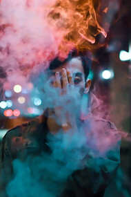 A figure, cloaked in a sleek black leather jacket, exudes an air of cool nonchalance as wisps of smoke curl around him, completing the scene with an edgy allure